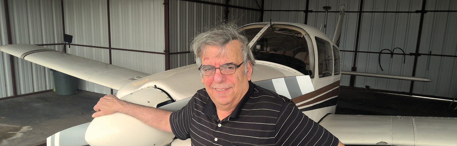 Photo of Allan Kash and his airplane.