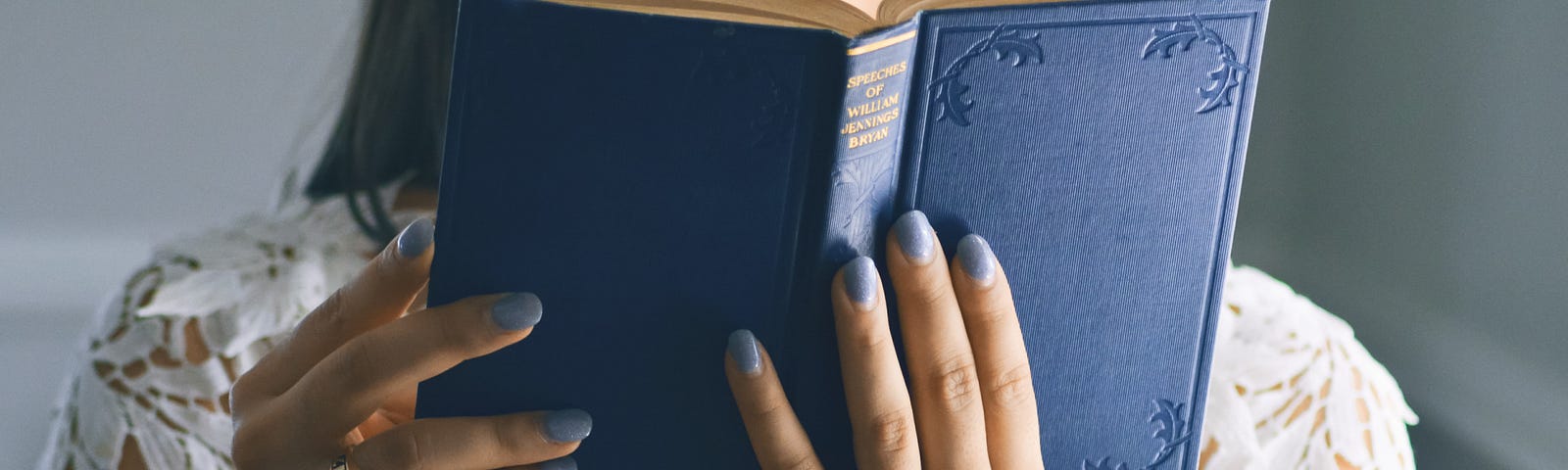 Woman reads book with blue cover