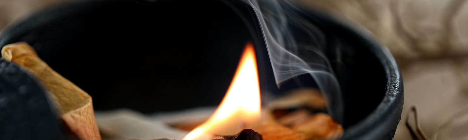A flame and smoke in a black bowl
