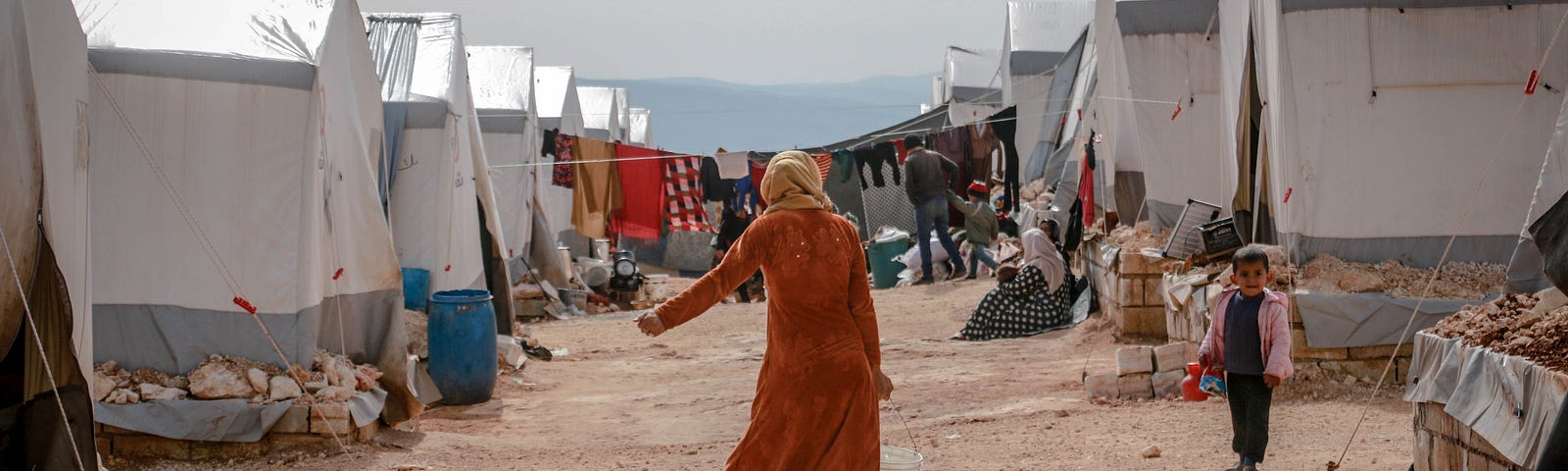 A woman walking in a refugee camp in Idlib, Syria
