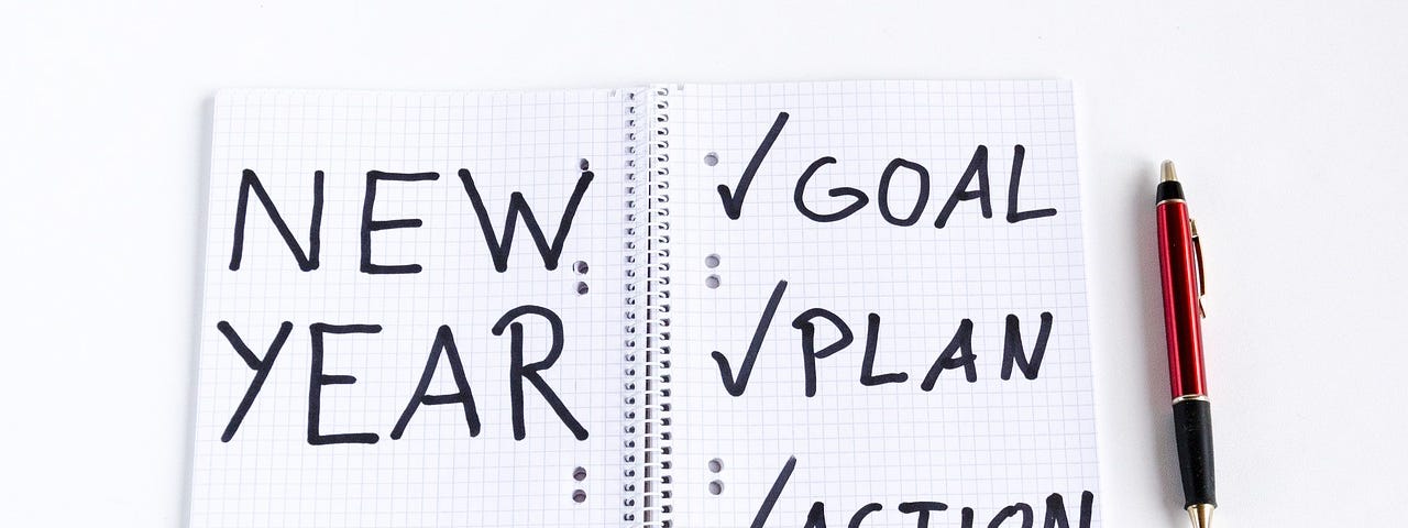 Open White Notebook With Words New Year, Goal, Plan And Action.