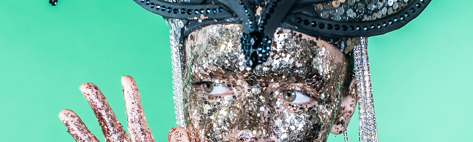 A woman covered in glitter with a big headpiece