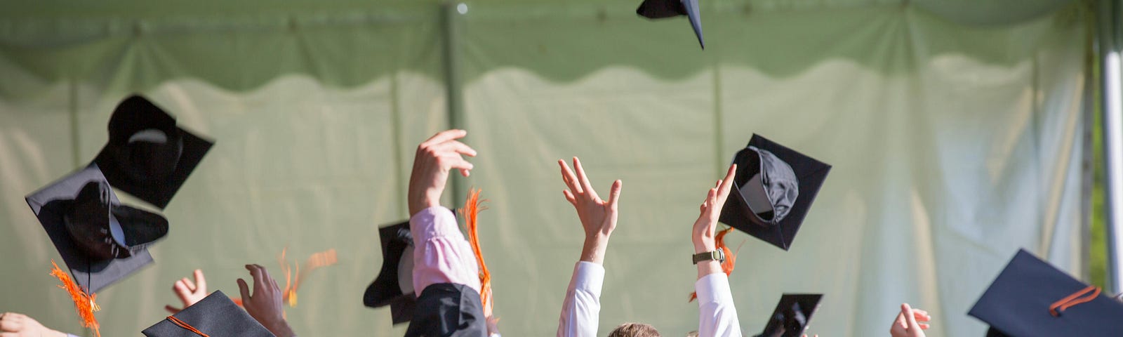 College students throwing their hats in the air at graduation