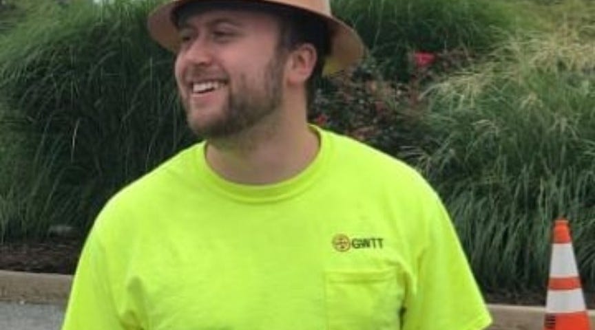 Ben smiles with a hardhat and neon yellow t-shirt.