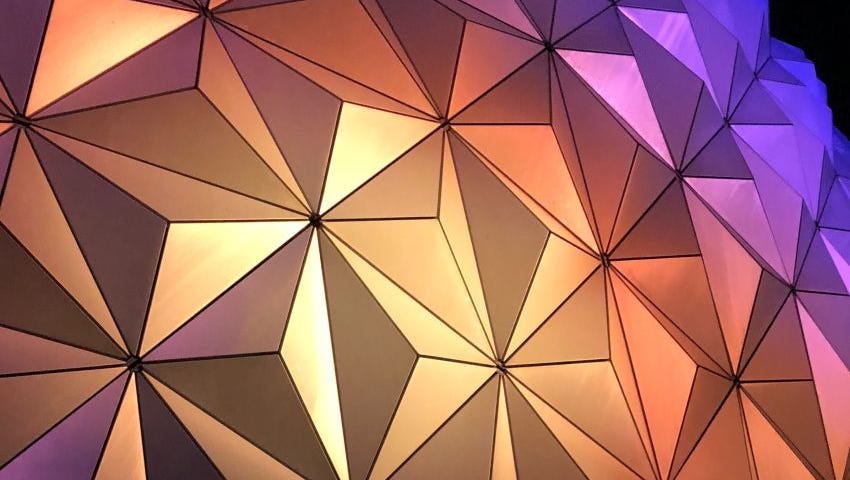 Abstract image of triangular textured lights in purple, yellow and orange