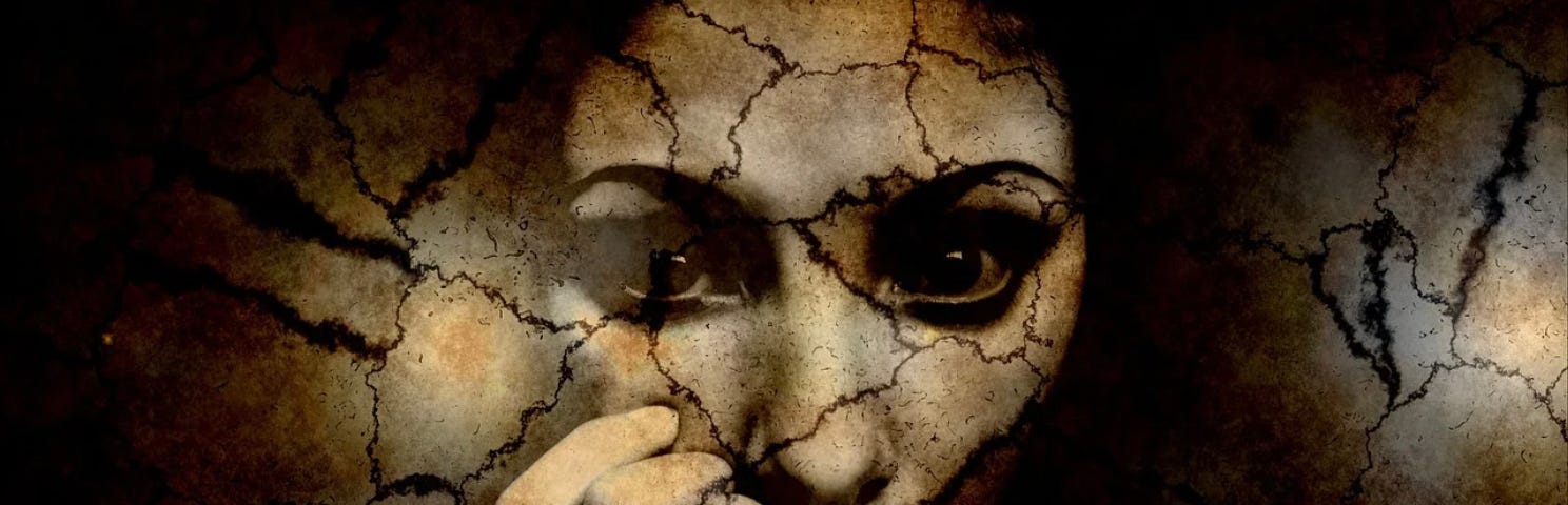 A woman’s face, cracked and broken.
