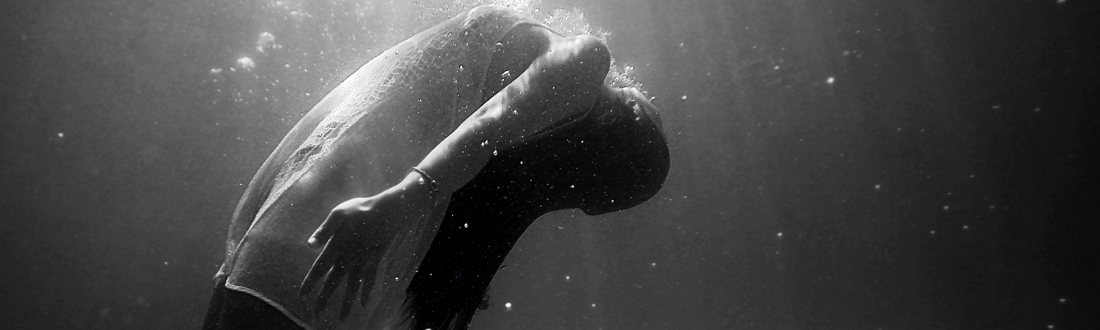 Photo by Christopher Campbell | Black and white photograph of woman floating in water