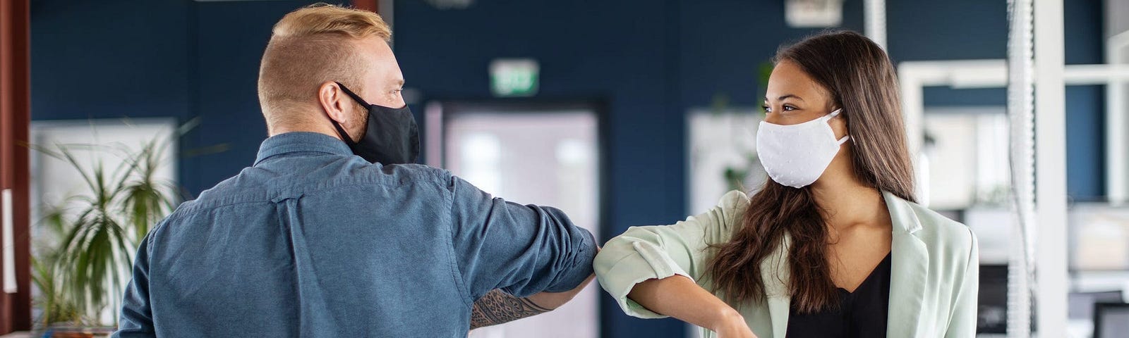 Two business colleagues greeting with elbow in office.