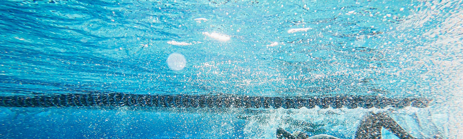 A woman in a black bikini swimming in a pool