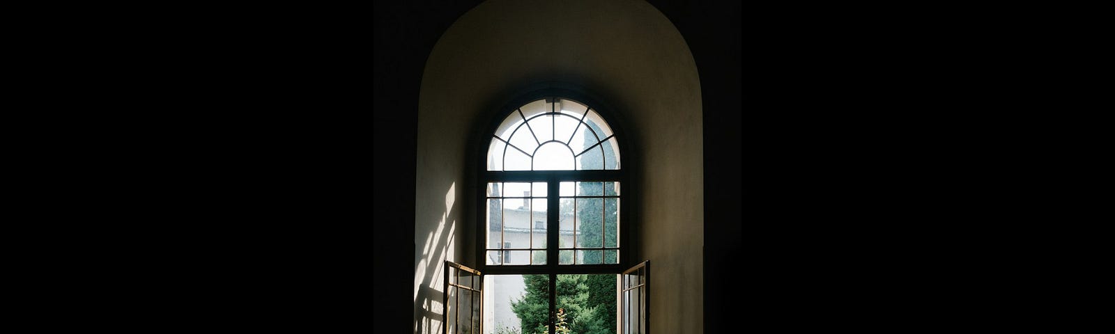 An open window letting light into a dark room