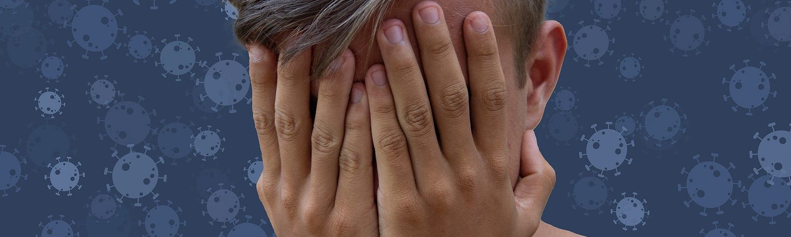 A person with short dark blond hair and a blue shirt with their hands covering their face.