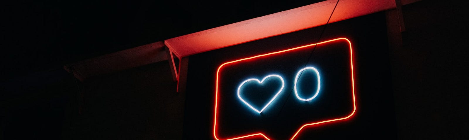 Neon signage of a social media heart icon with a zero next to it.