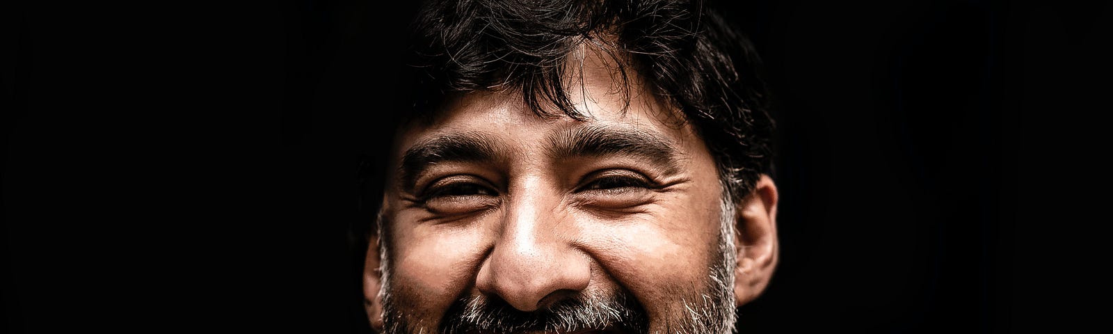 Man with dark hair, salt and pepper beard, mustache