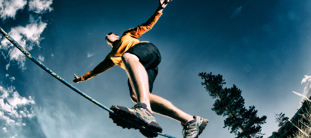 A person balancing on a slack line outside