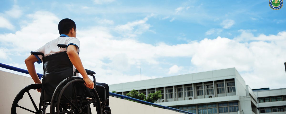 Man in wheelchair on walkway.