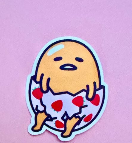 Photo of the lazy yellow egg wearing egg shell shorts with strawberry hearts on them.