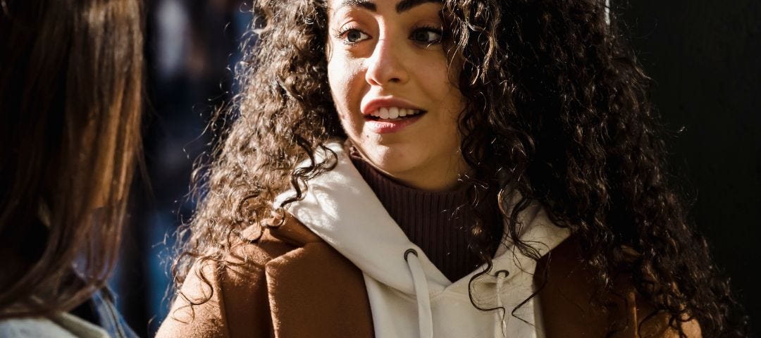 smiling woman talking to the profile of another woman