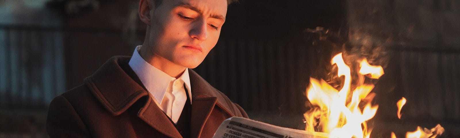 A man reading a burning newspaper