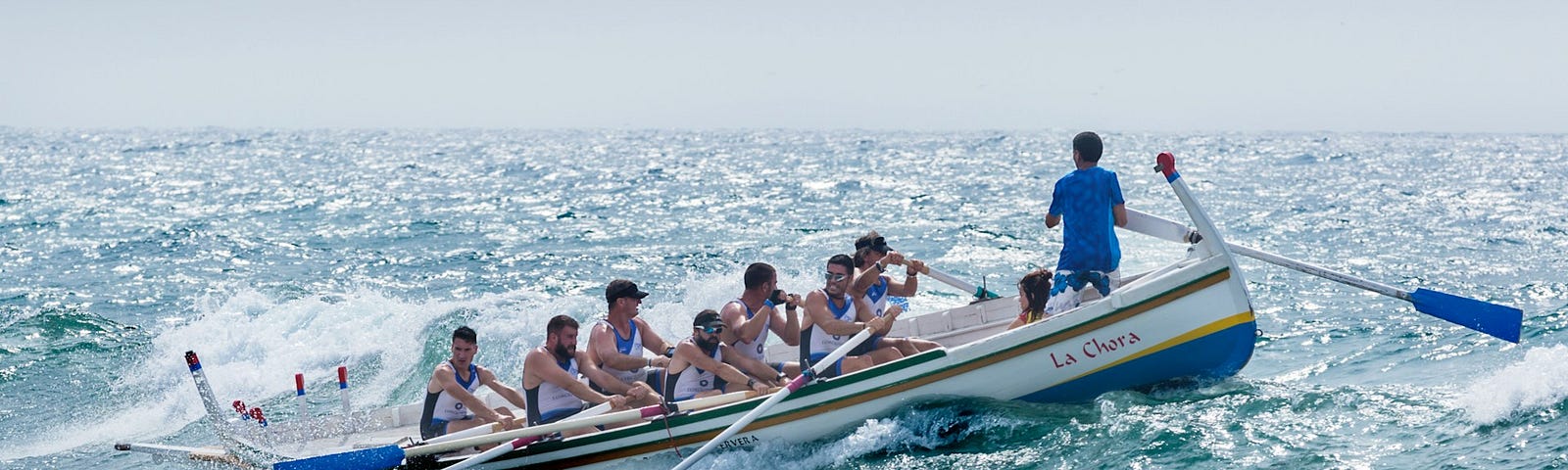 Team of boys riding a boat in rough sea