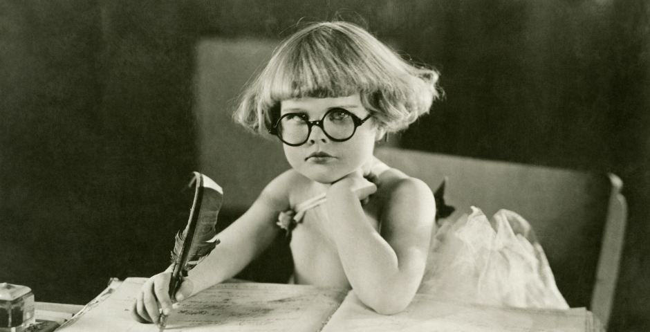 Young girl writing with quill pen