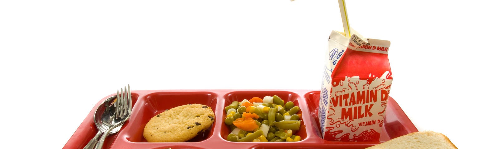 school lunch on red tray. chicken nuggets, boxed milk and chocolate chip cookie.