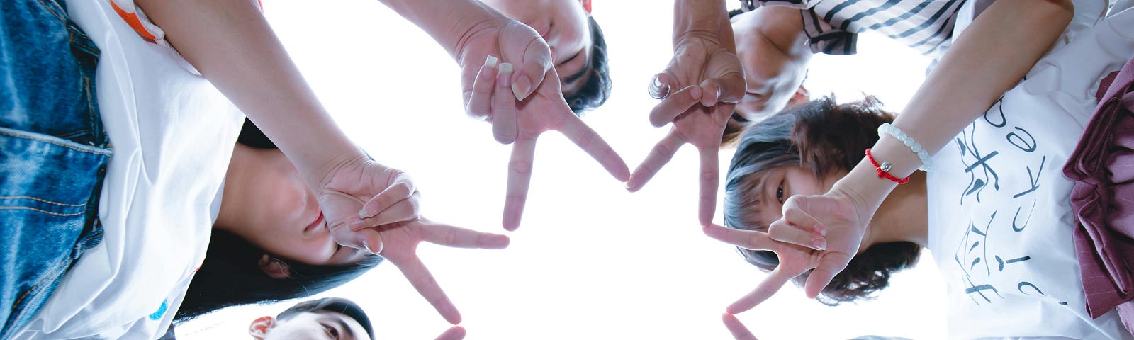 Group of people forming a star with their fingers