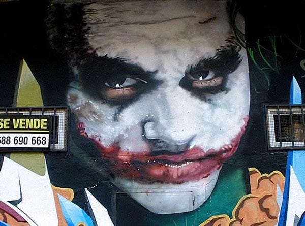 Painted mural of a scary joker/clown with evil face paint and expression