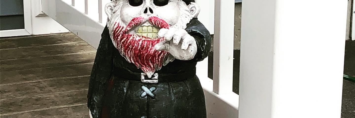 picture of decorative gnome dressed in all black with a blood stained beard
