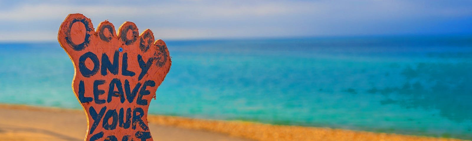 Picture: Sign on a beach in the form of a foot saying only leave your footprints.