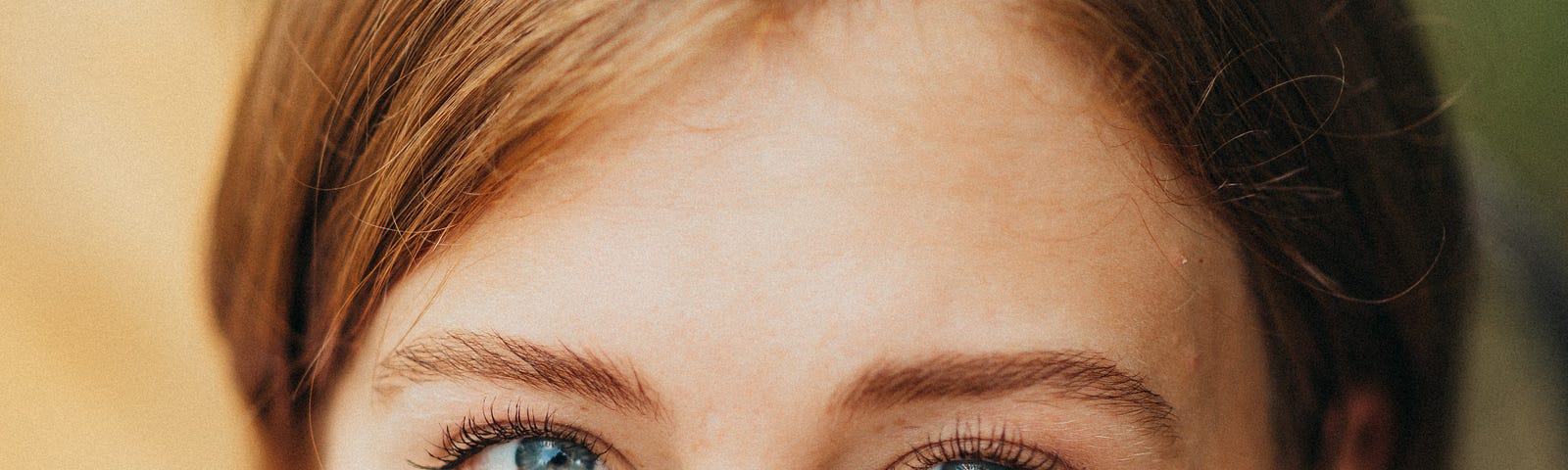 close up of a young woman’s face, eyes looking up, in serious comtemplation