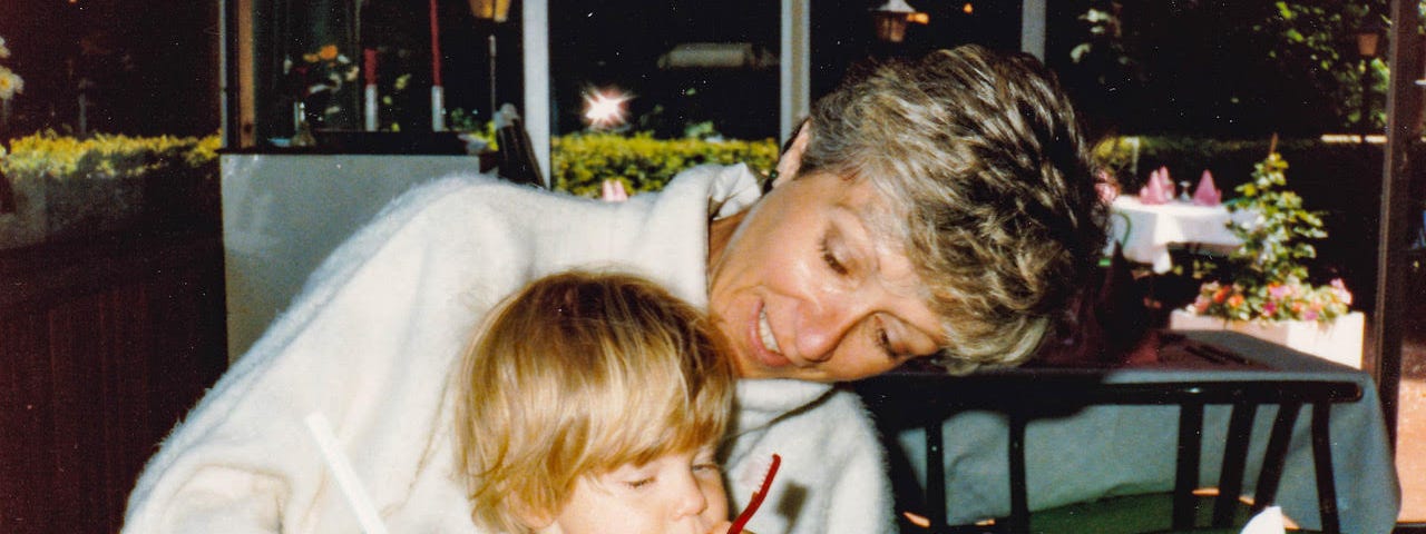 A woman bends lovingly towards the small child on her lap.