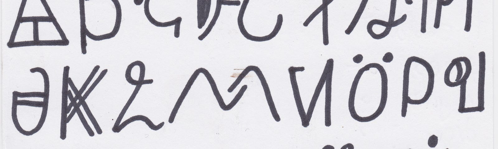 Black sharpie pen written on white thin postcard, running through the alphabet from A in the top left, to Z bottom right.