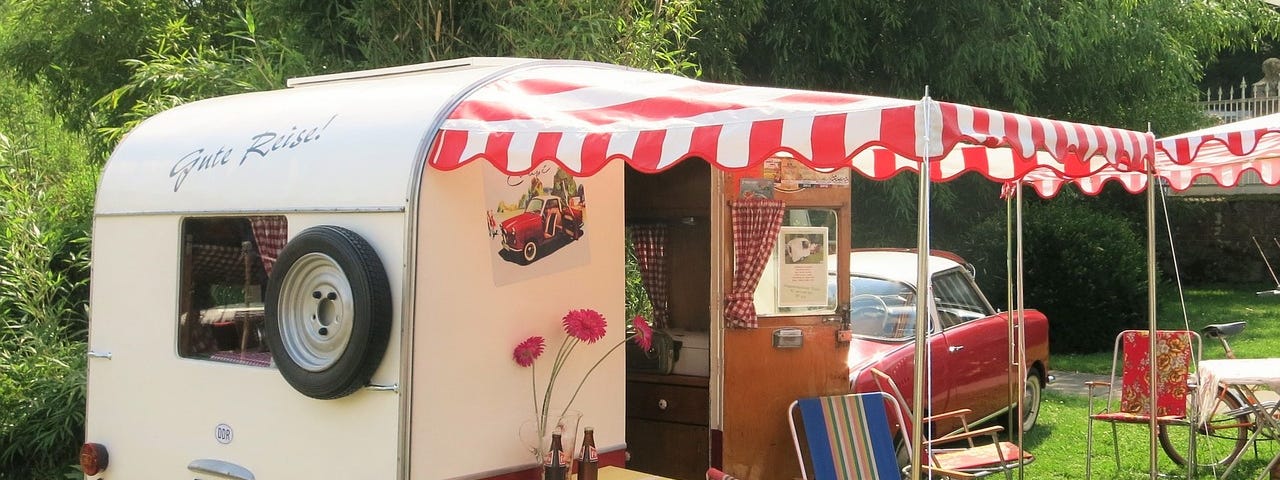 A old caravan with annex and vintage car