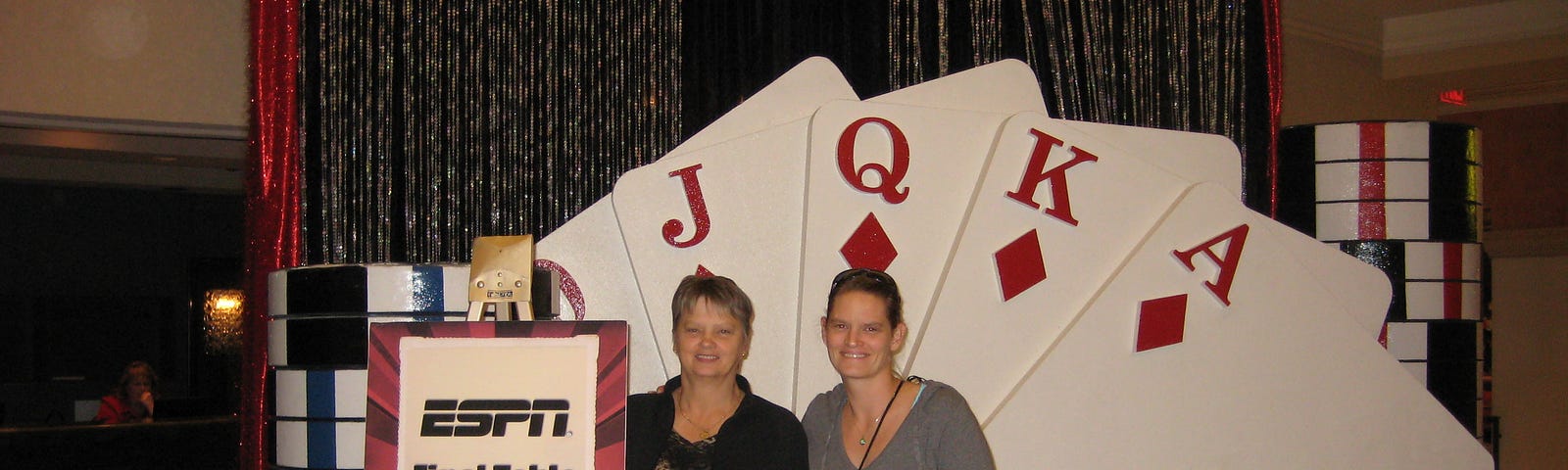 My mom and I standing in front of and ESPN Final Table sign with an arrow.
