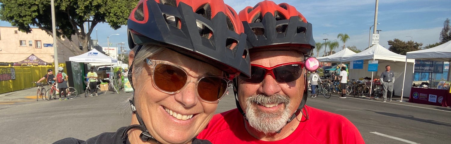 Photo of author and her husband with bicycle helmets.