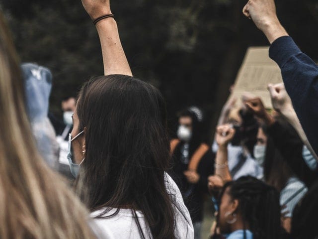 Masked people of color with fists in the air