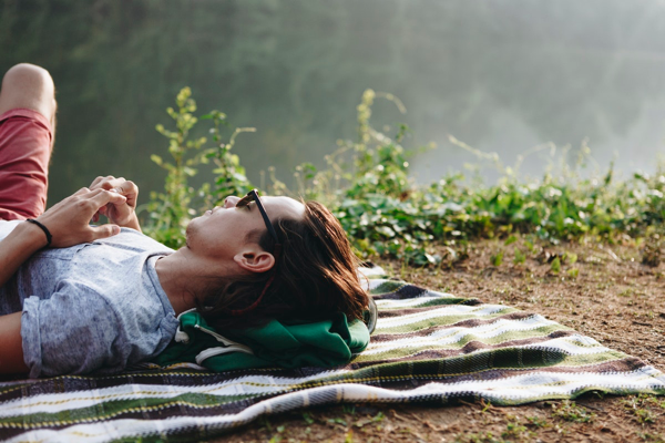 Man relaxing on a blanket in a natural setting