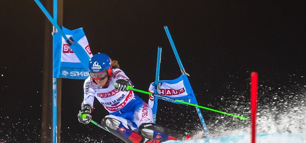 A female athlete is alpine skiing during World Cup