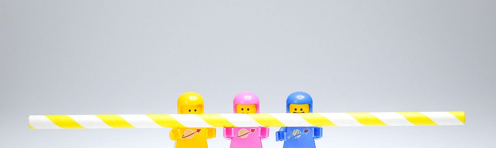 Three lego people in different coloured outfits