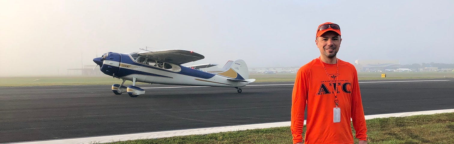 Ross posing in front of a runway.