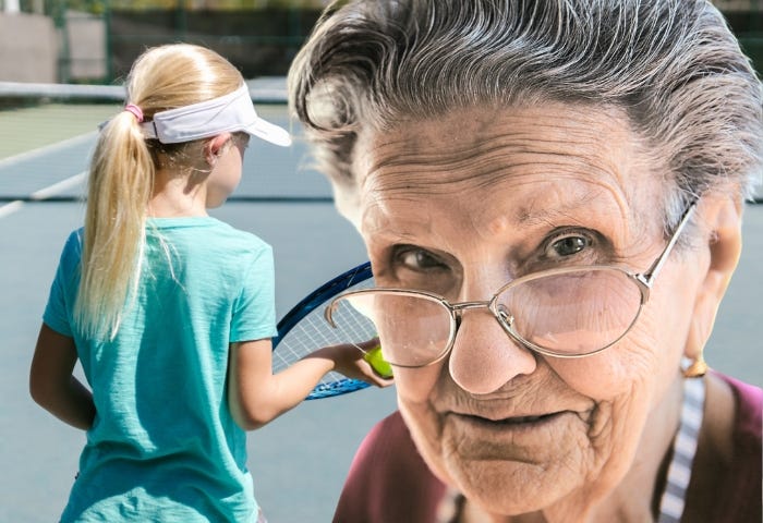 A frustrated grandmother looks in the camera because she has to play tennis with her granddaughter who can’t play.
