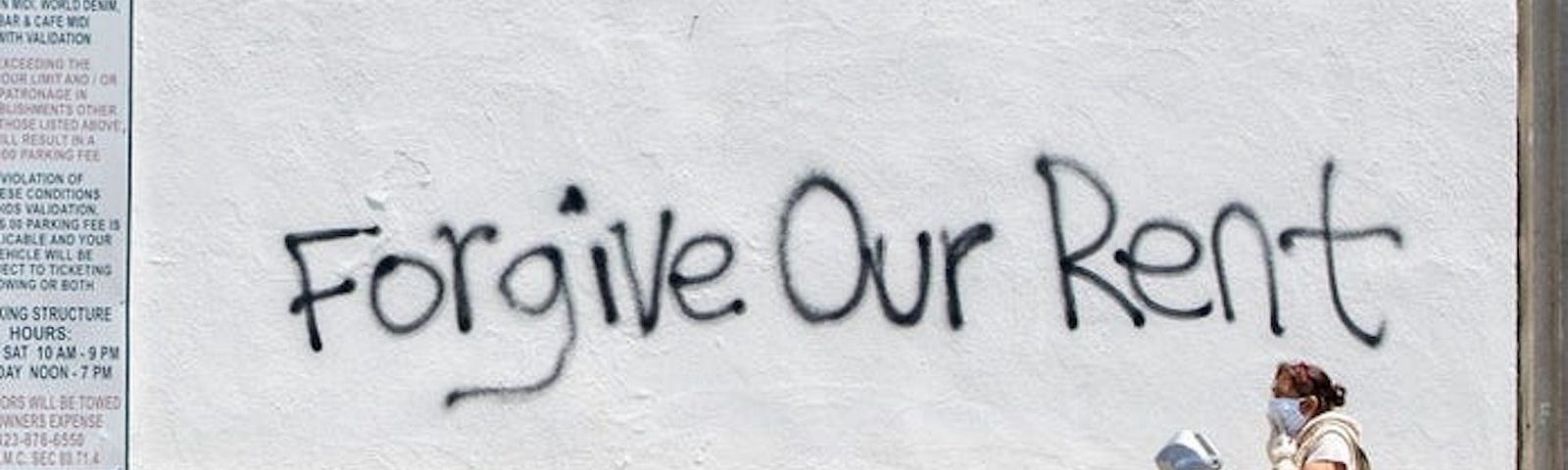 “Forgive our rent” graffiti on the wall.