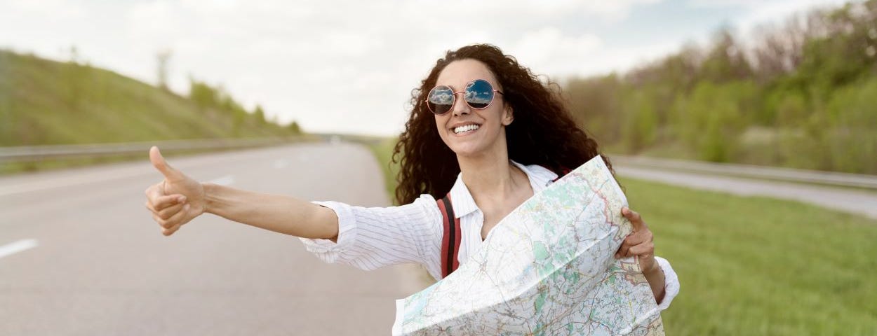 A young woman hitch-hiking.