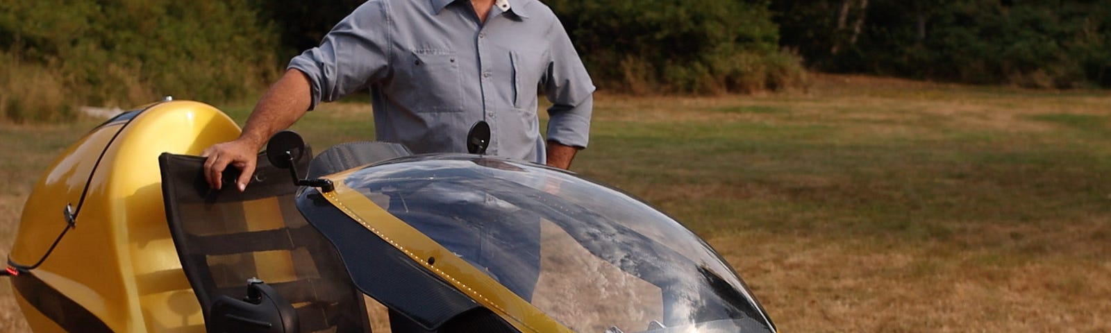 The Electrom LEV in the color yellow with the founder standing proudly by the vehicle.