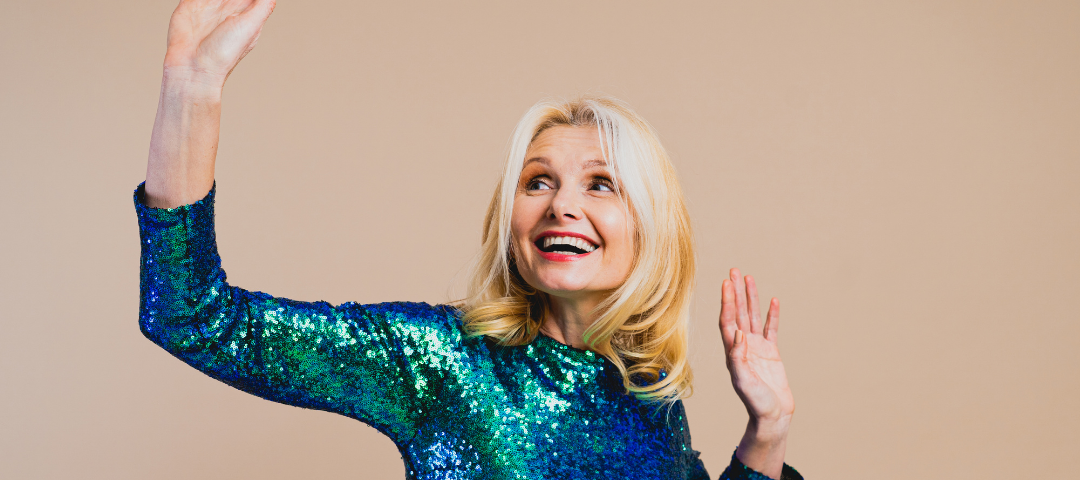 An older woman in a shimmery green dress looking happy