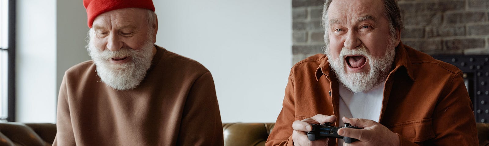 Two bearded older men in brown shirts play a video game