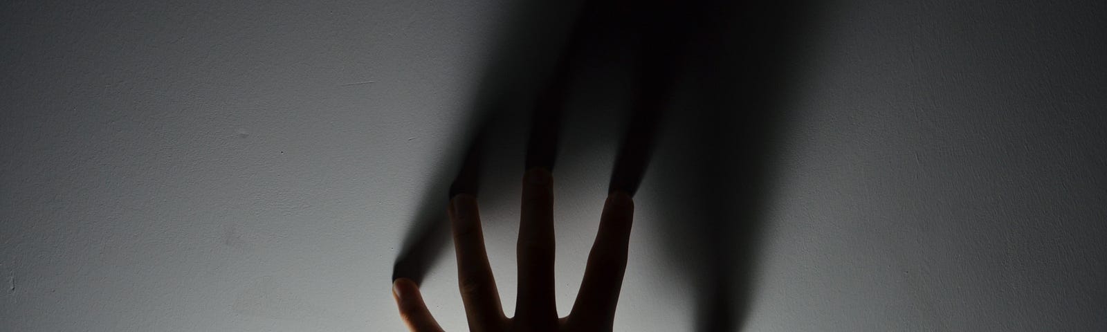 The silhouette of a hand reaching out.