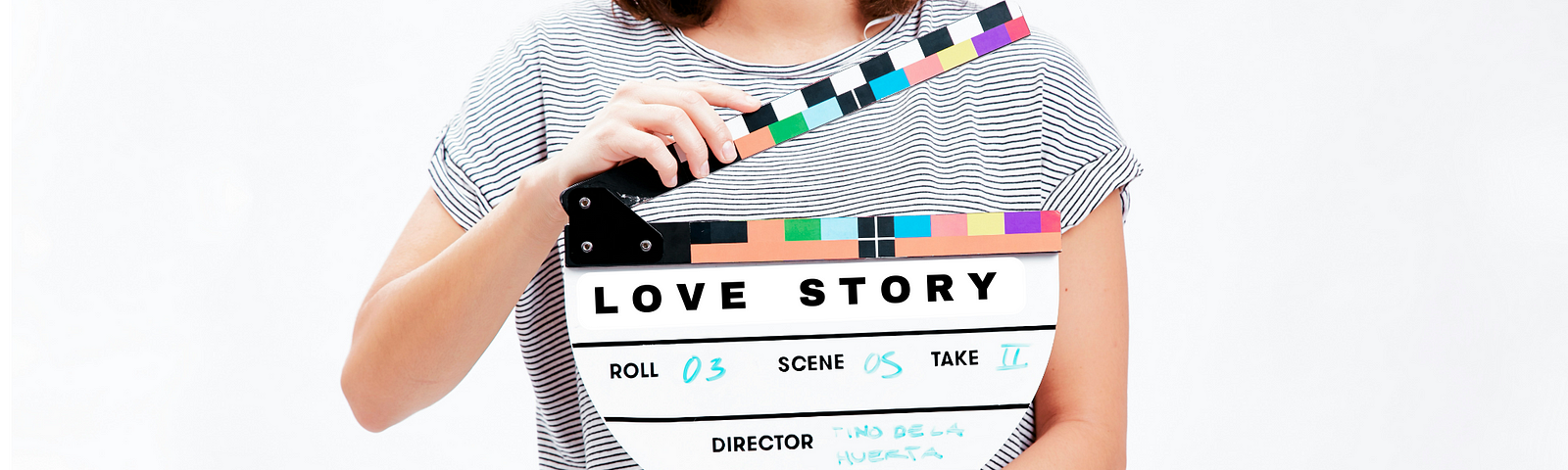 Woman holding a movie clipboard featuring the words Love Story, ready for action