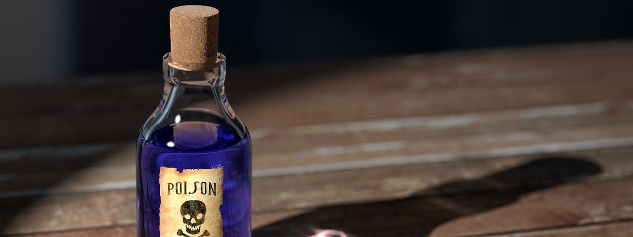 IMAGE: On a wooden table, a bottle with a purple liquid labeled as “Poison”