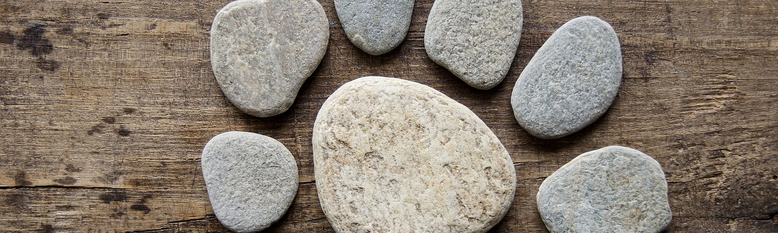 A circle of small grey stones, with a larger white one in the centre.